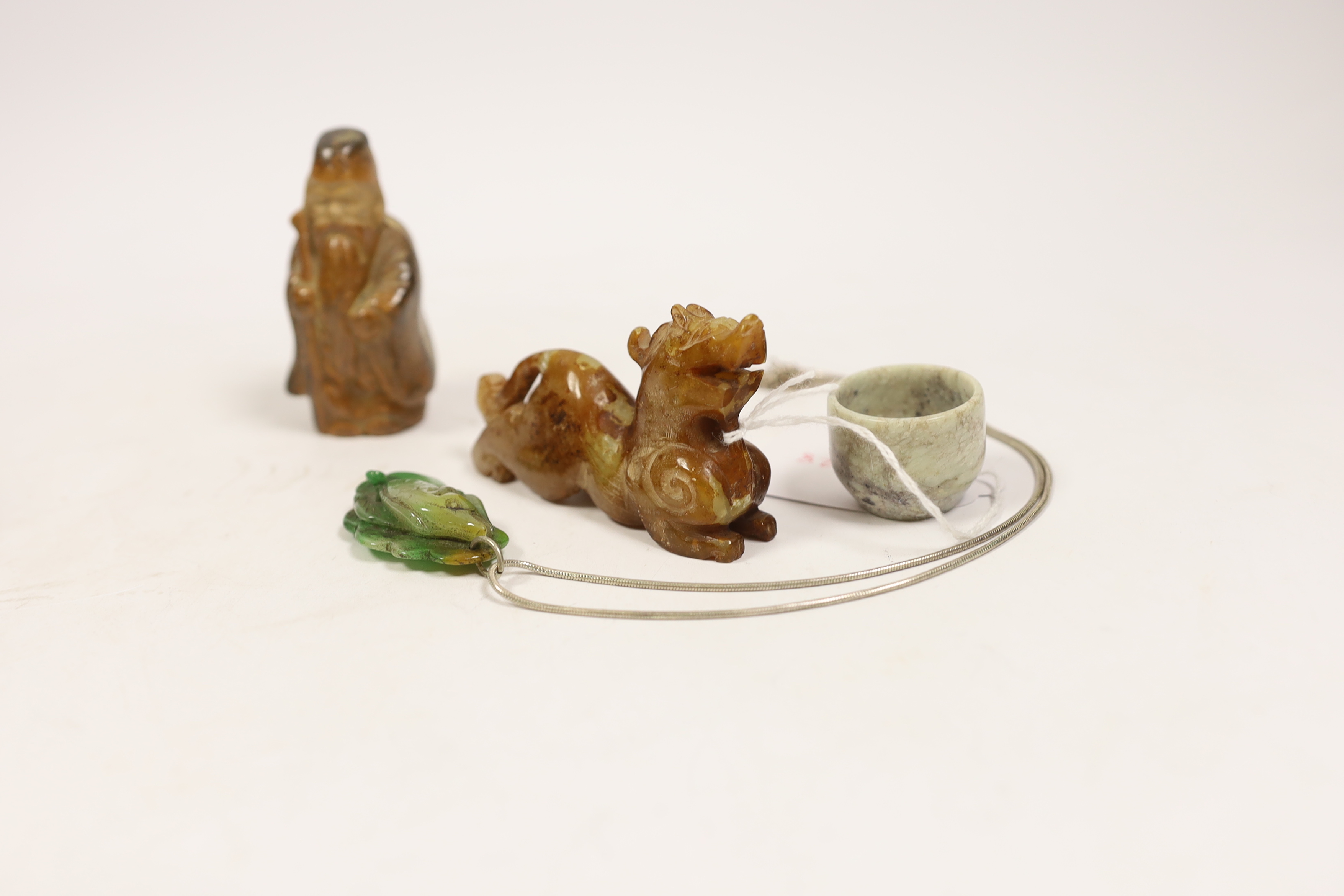 Six Chinese items including a carved jade fish pendant, a jade ring, a bowenite jade figure, an agate carved dragon, an earthenware miniature figure and a miniature carved stone bowl